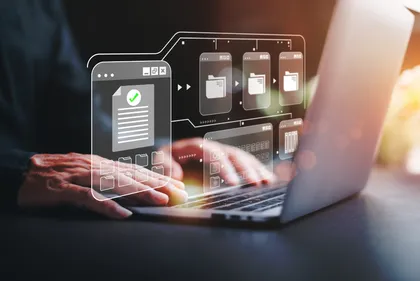Une personne utilisant un ordinateur portable avec des éléments graphiques numériques flottants représentant la gestion de fichiers et de données.