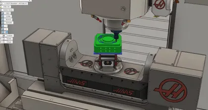 Une machine CNC en fonctionnement sur une pièce verte. La machine est une Haas, utilisé pour l'usinage de précision.