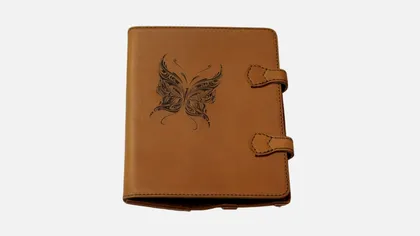 Carnet en cuir marron avec une illustration de papillon noir sur la couverture