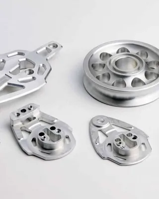 Pièces mécaniques en aluminium sur fond blanc.