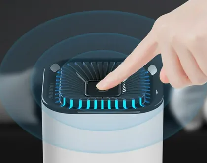 Une main poussant un bouton sur un appareil électronique avec un affichage lumineux bleu.