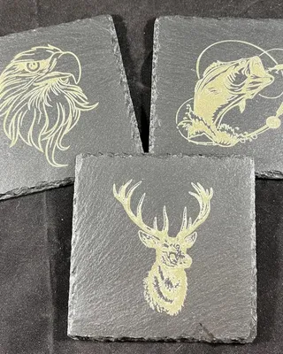 Trois carreaux de pierre gravés représentant un aigle, un poisson et un cerf avec des bois.