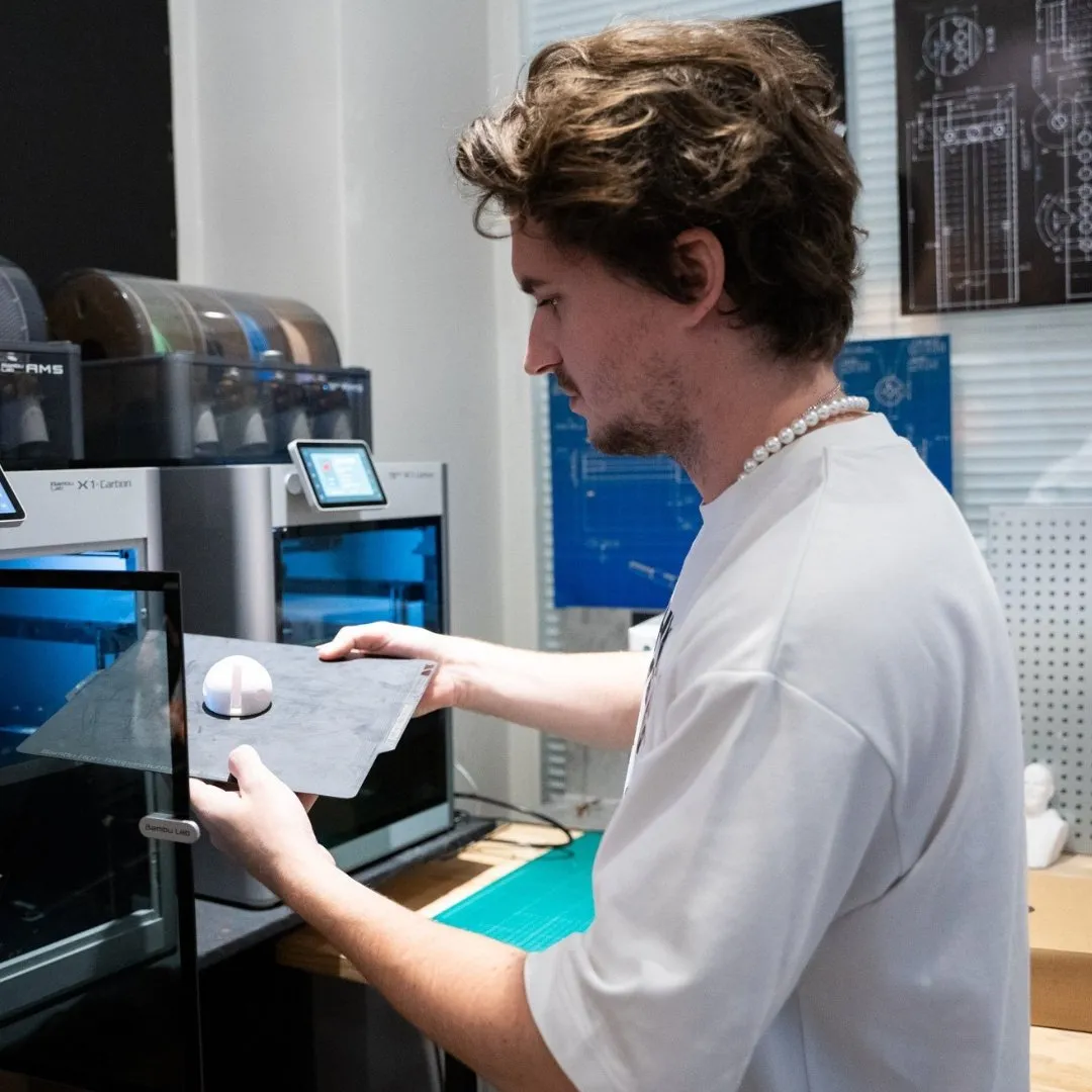 stagiaire posant le plateau d'impression 3d