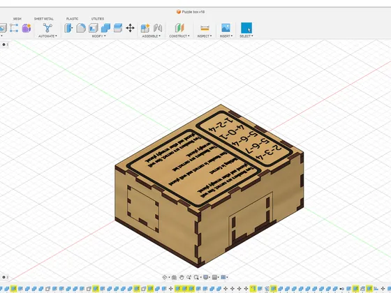 Modèle 3D d'une boîte à puzzles en bois avec des inscriptions sur le dessus, affichée dans Autodesk Fusion 360.