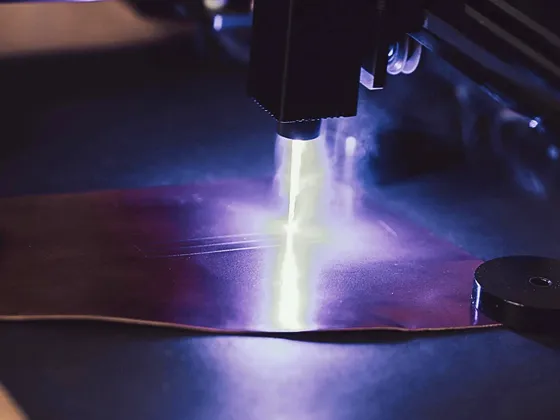 Une machine de soudage laser en action, avec un faisceau lumineux brillant sur une plaque métallique