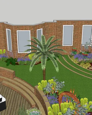 Plan de jardin avec pelouse, palmiers, fleurs colorées, terrasse en bois et maison en briques.