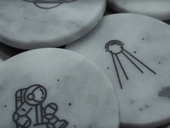 Dessins gravés illustrant un astronaute et un signal radio sur des pierres en marbre.