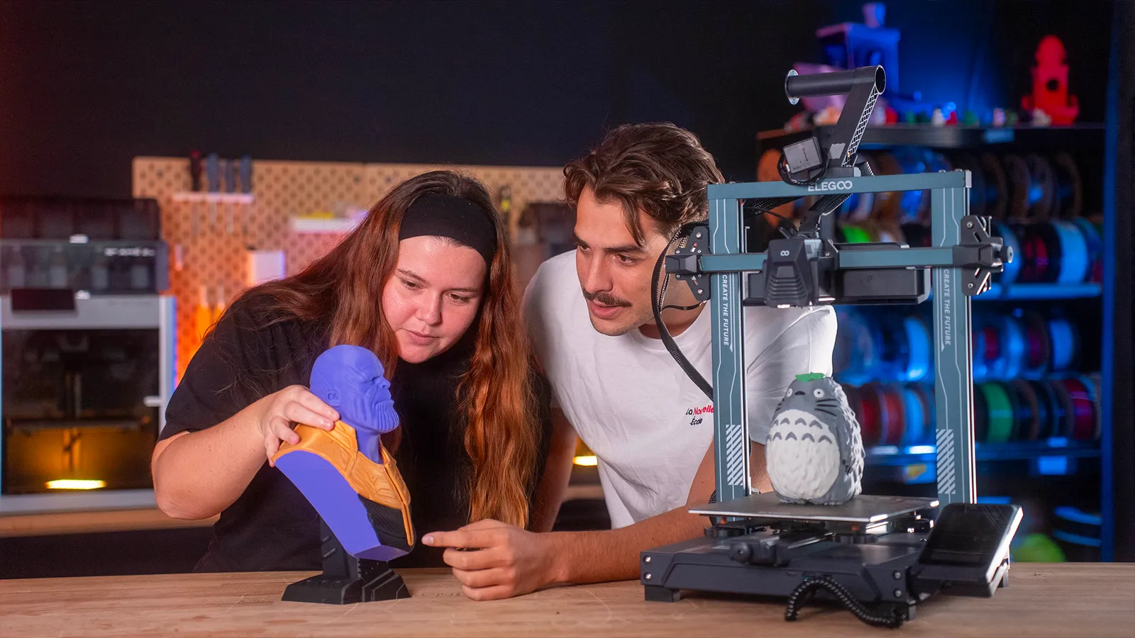 Deux personnes travaillant sur une imprimante 3D dans un atelier