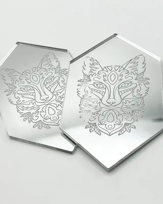 Deux miroirs en forme d'hexagone avec une image de renard stylisé gravée dessus.