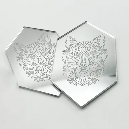 Deux miroirs en forme hexagonale avec un dessin de tête de renard stylisée gravée dessus, reflétant légèrement l'un dans l'autre.