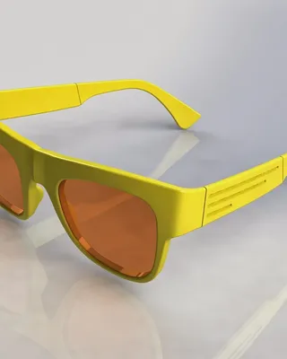 Lunettes de soleil jaunes avec des verres orange sur une surface blanche