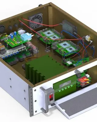 Intérieur d'une boîte électronique contenant des circuits imprimés, des composants électroniques, des câbles, un dissipateur thermique et une interface de contrôle avec écran et boutons.