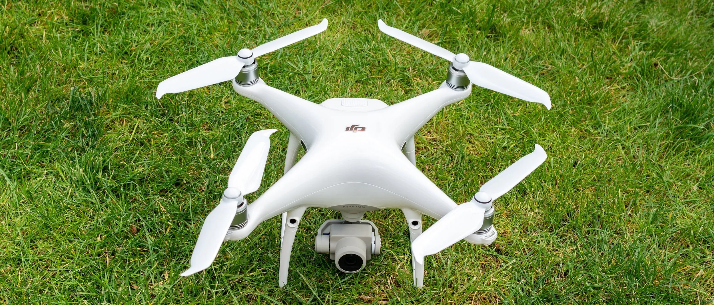 drone blanc avec camera sur de l'herbe