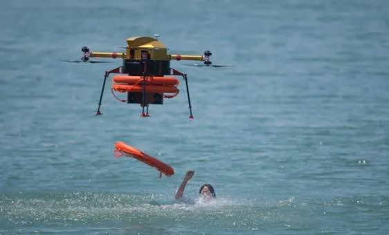drone en operation d'urgence en train de jter une bouée à une personne qui se noie