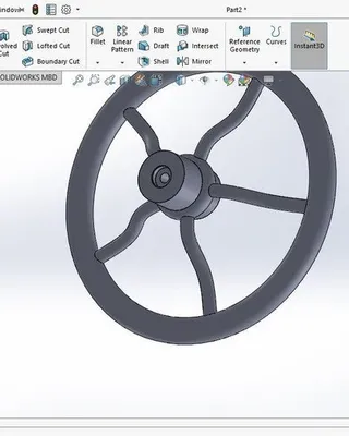 Capture d'écran d'une modélisation 3D dans SOLIDWORKS montrant une pièce mécanique en forme de roue avec une structure centrale et quatre bras radiaux.