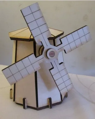 Une maquette en bois d'un moulin à vent avec quatre ailes, placée sur une table.