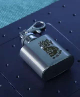 Cadenas de calibre, clé et une serrure en acier posés sur une surface noire perforée.