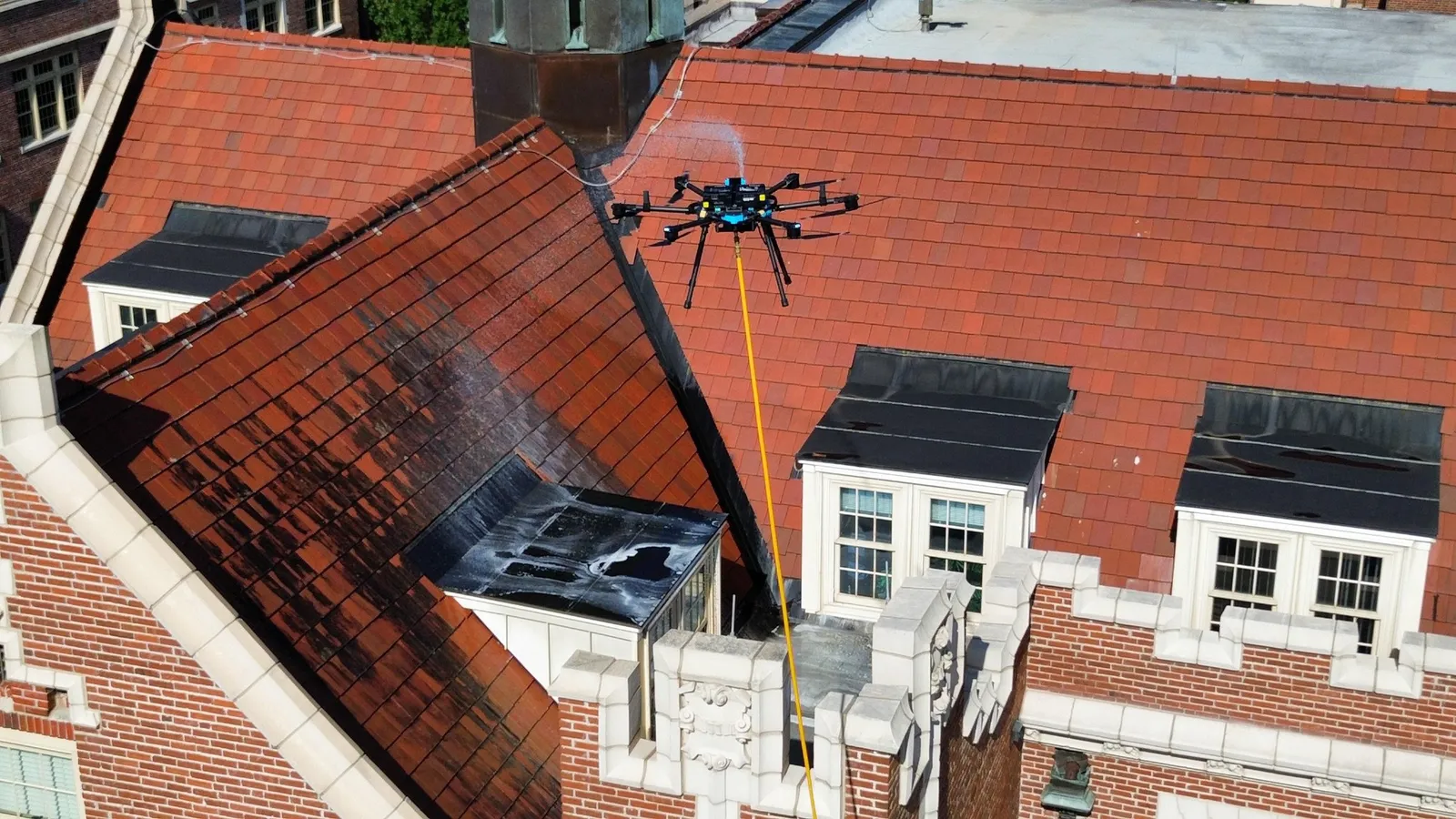 Drone équipé d'un dispositif de nettoyage pulvérisant un produit sur une toiture