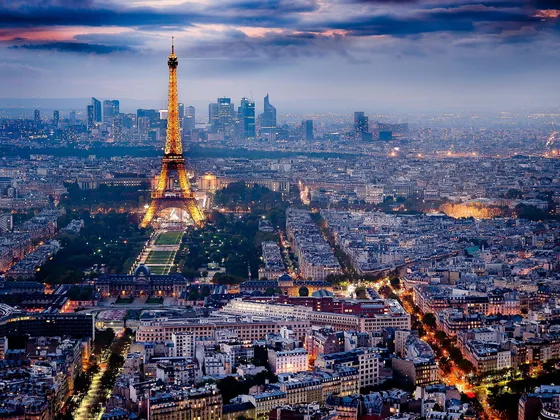 Vue aérienne de Paris au crépuscule avec la Tour Eiffel illuminée et l'ouest de la ville