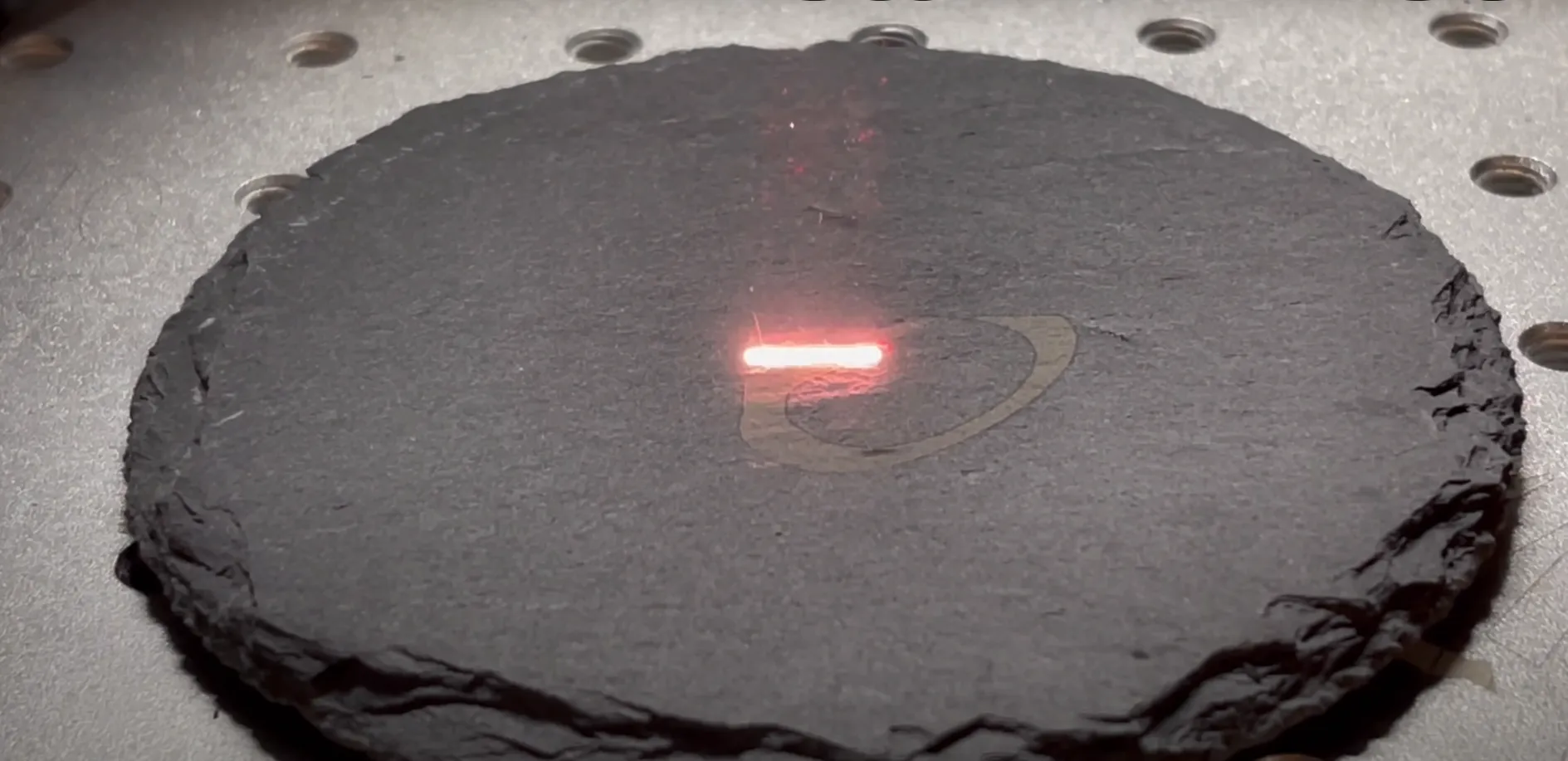 pierre en train d'être gravé avec laser rouge